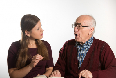 woman teaching a senior man to talk properly